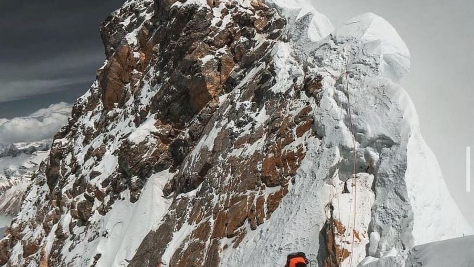 Everest keynote speaker climbing a fixed rope along the exposed summit ridge of Mount Everest