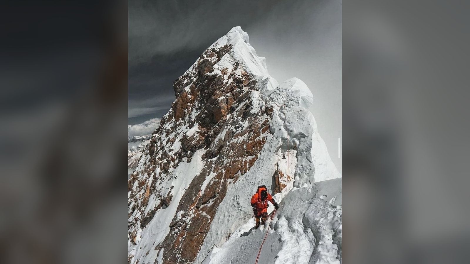 Everest keynote speaker climbing a fixed rope along the exposed summit ridge of Mount Everest