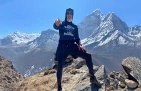 Everest keynote speaker climbing a fixed rope along the exposed summit ridge of Mount Everest